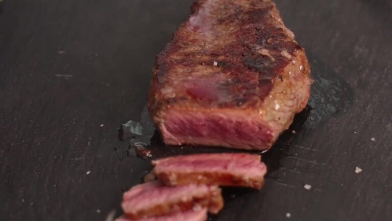 Stek Black Angus w marynacie z rozmarynu i czosnku, przekrojony na desce